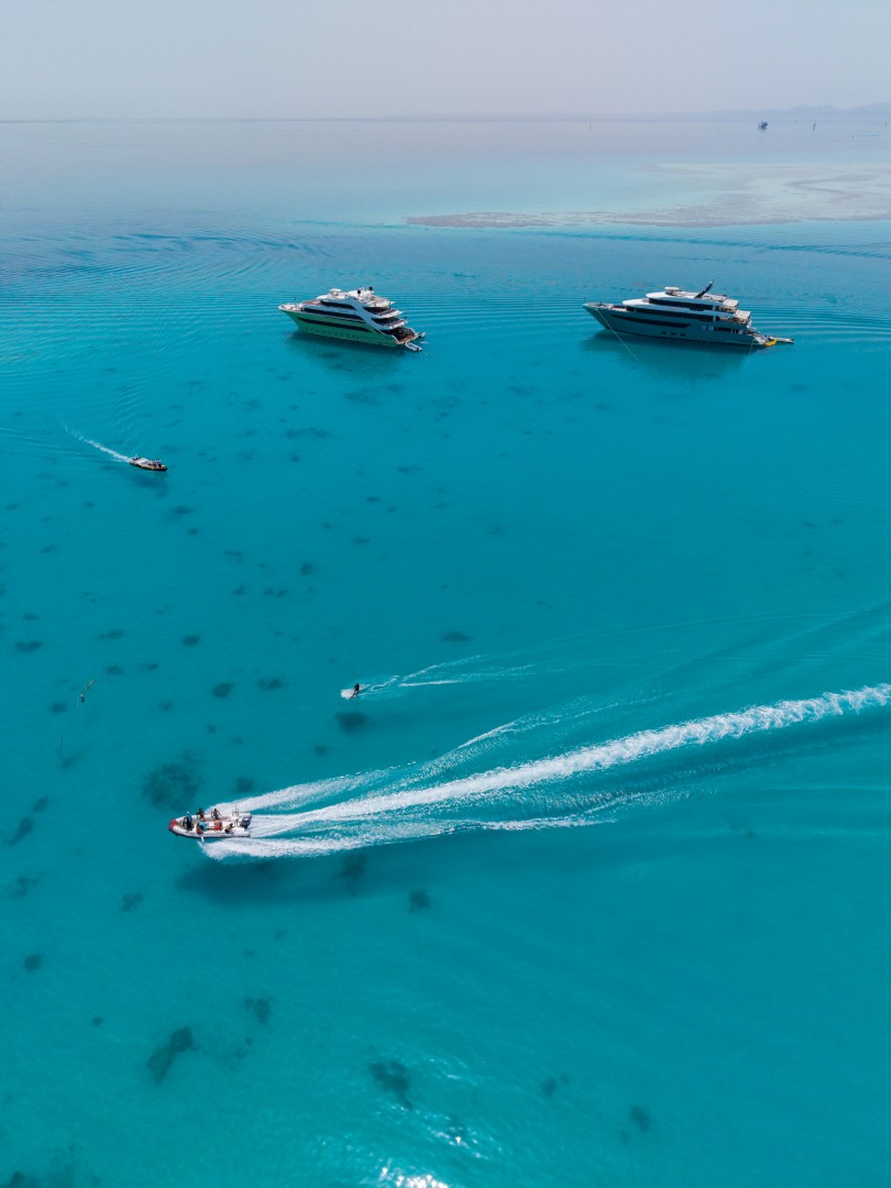 Aerial view of the yachts moored over turquoise reefs along the route